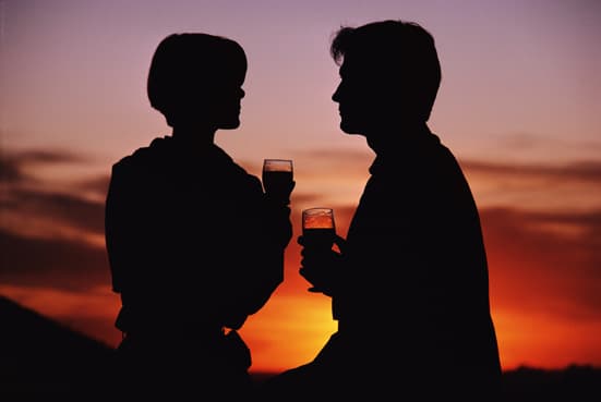 Bild von einem Paar das beim Sonnenuntergang ein Gläschen Wein trinkt